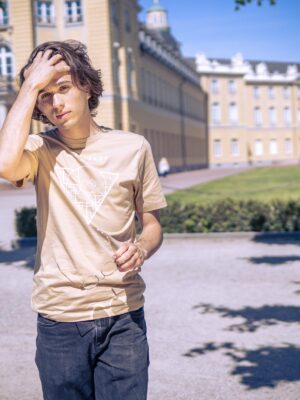 Männliches Model trägt ein sandfarbenes Unisex T-shirt, bedruckt mit Karlsruhe Map Motiv