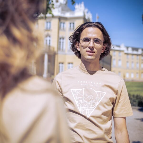 Männliches Model trägt ein sandfarbenes Unisex T-shirt, bedruckt mit Karlsruhe Map Motiv