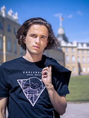 Männliches Model trägt ein schwarzes Unisex T-shirt, bedruckt mit Karlsruhe Map Motiv