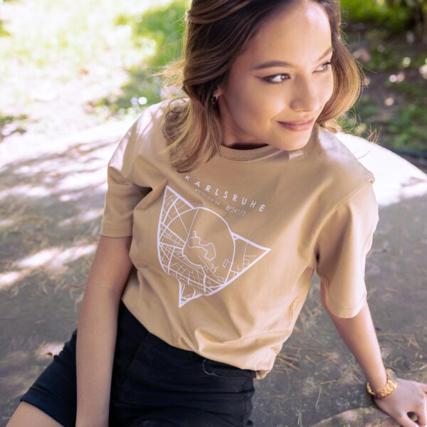 Weibliches Model trägt ein sandfarbenes Unisex T-shirt, bedruckt mit Karlsruhe Map Motiv