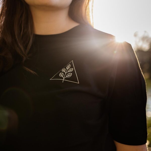 Nahaufnahme schwarzes Unisex T-Shirt mit weißem Pflanzenmotiv und Dreieck