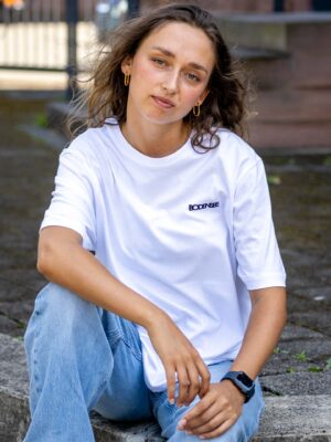 Weibliches Model trägt ein weißes Unisex T-shirt, bedruckt mit schwarzem Bodensee Tag