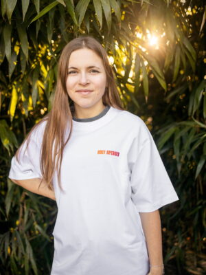 Ganzkörperaufnahme in weißem Box Tee Shirt mit orangenen HOLY APEROLY Wortzug