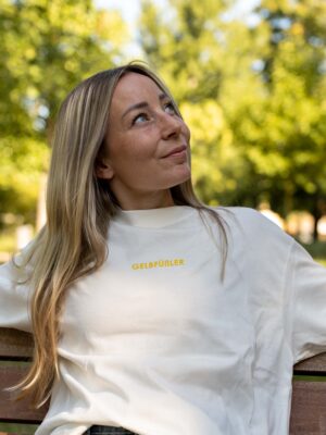 Ganzkörperaufnahme in weißem Box Tee Shirt mit gelbem Gelbfüßler Wortzug