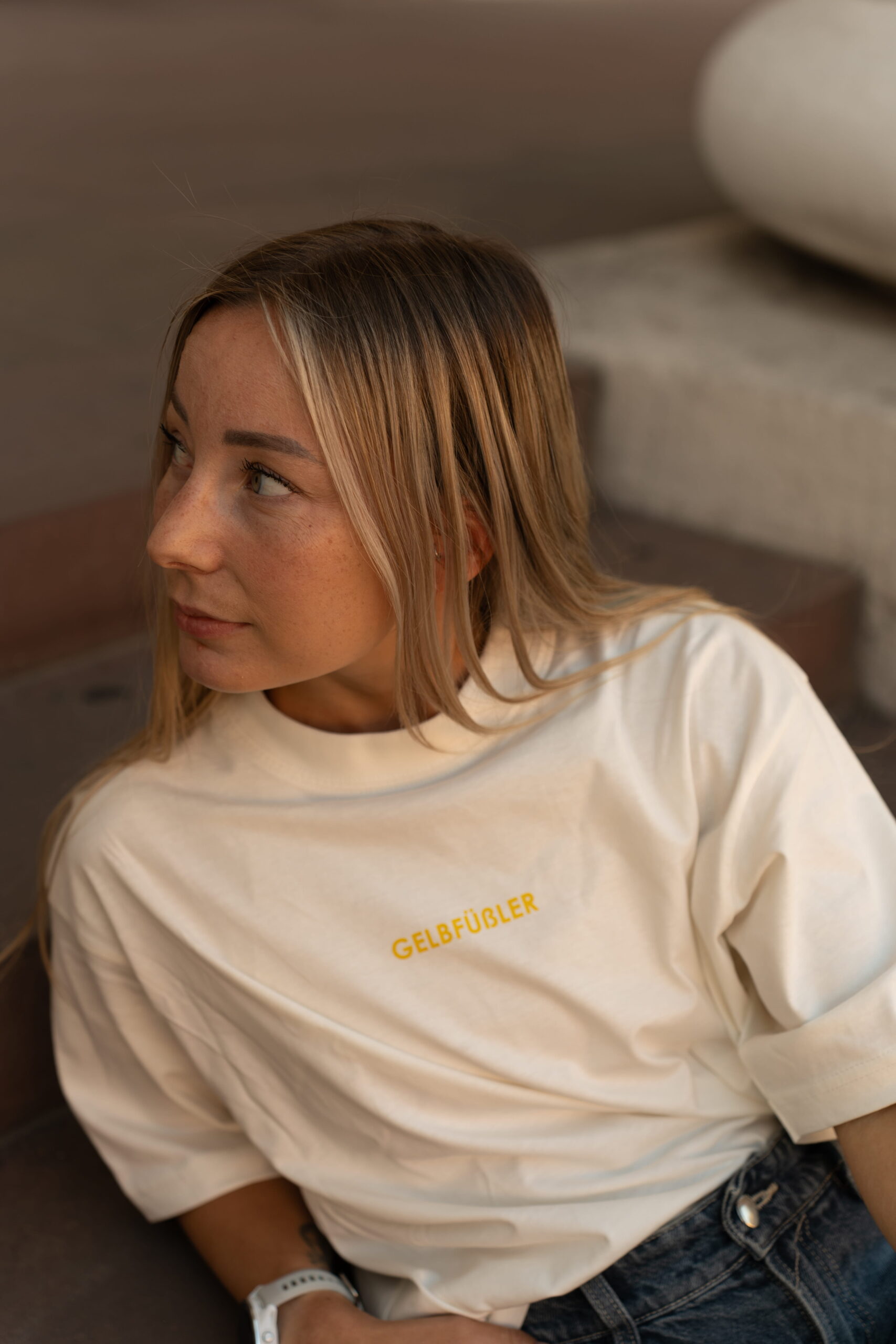 Ganzkörperaufnahme in weißem Box Tee Shirt mit gelbem Gelbfüßler Wortzug