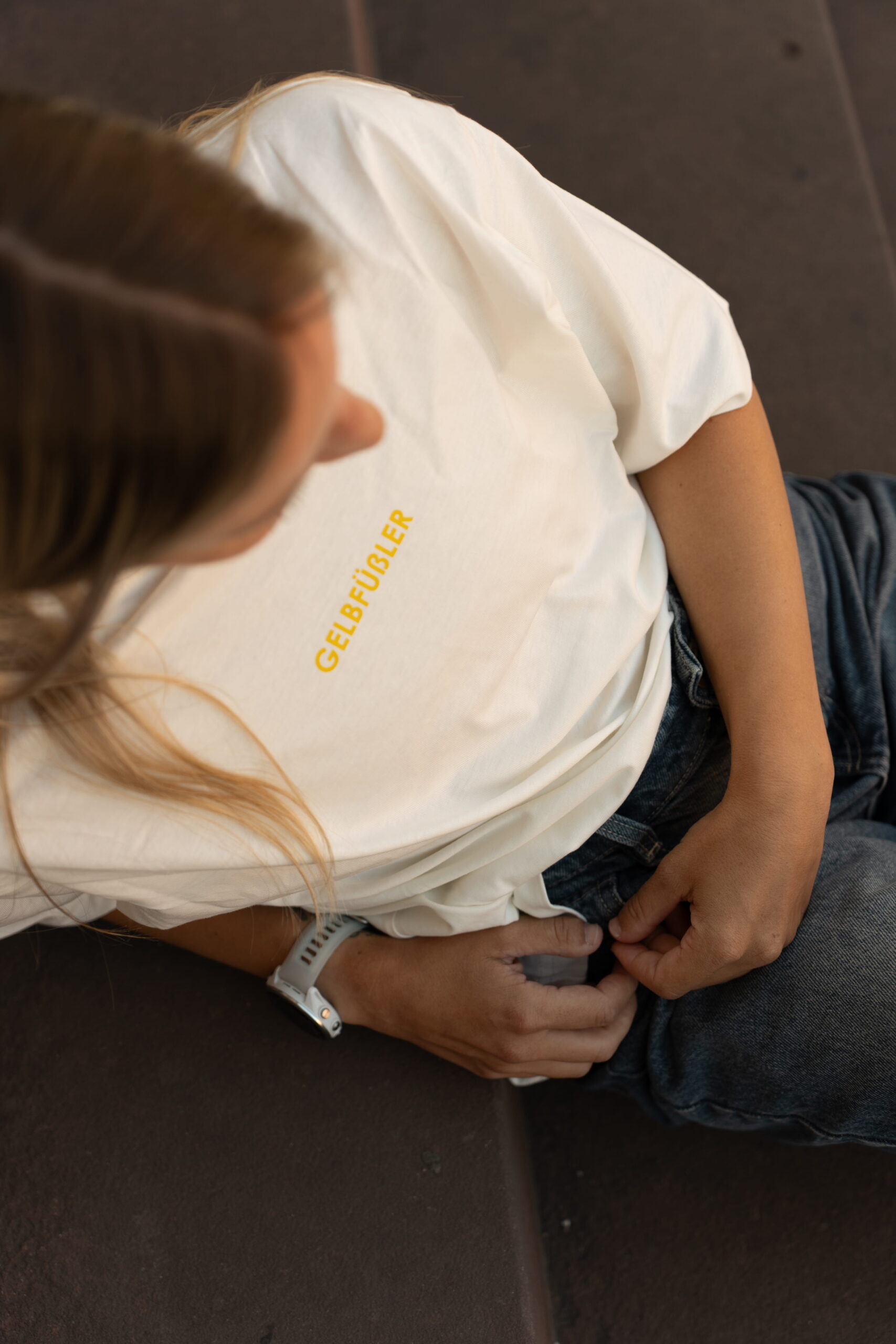Ganzkörperaufnahme in weißem Box Tee Shirt mit gelbem Gelbfüßler Wortzug